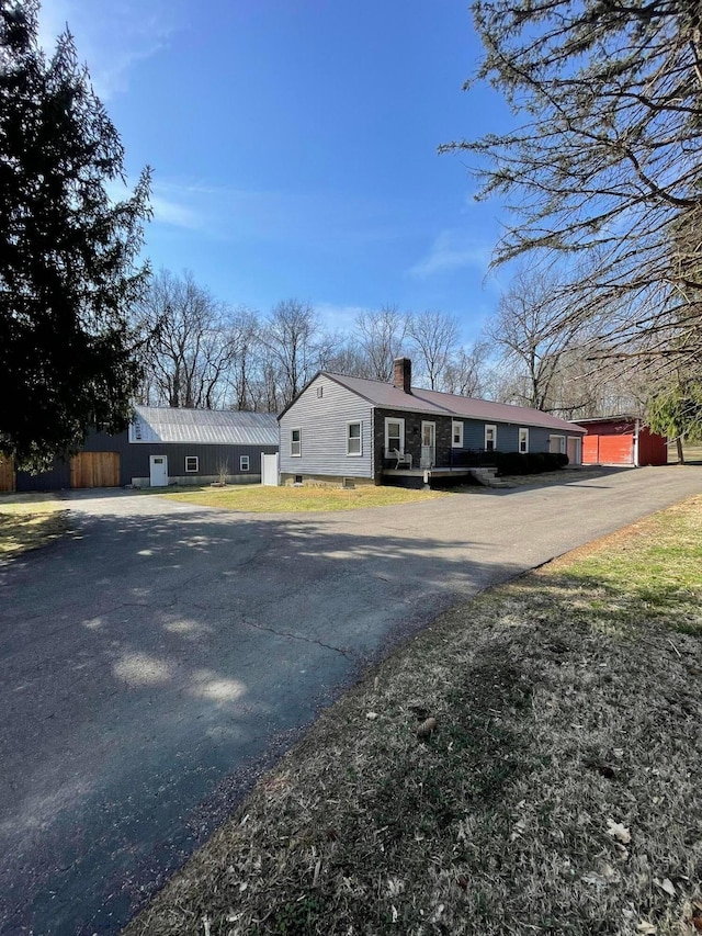 view of front of home featuring aphalt driveway and a chimney