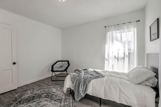 bedroom featuring baseboards and wood finished floors