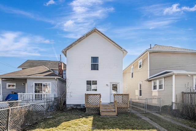 back of property featuring a gate, a fenced backyard, and a lawn