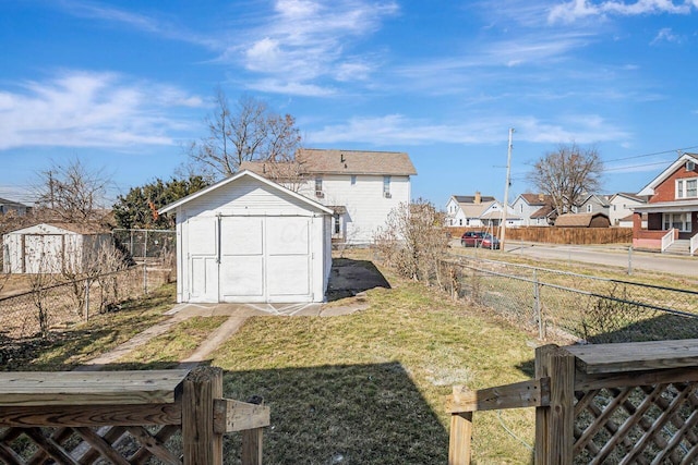 view of yard featuring a residential view, an outdoor structure, a fenced backyard, and a shed