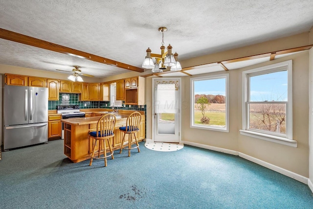 kitchen with a sink, white electric range, a healthy amount of sunlight, and freestanding refrigerator