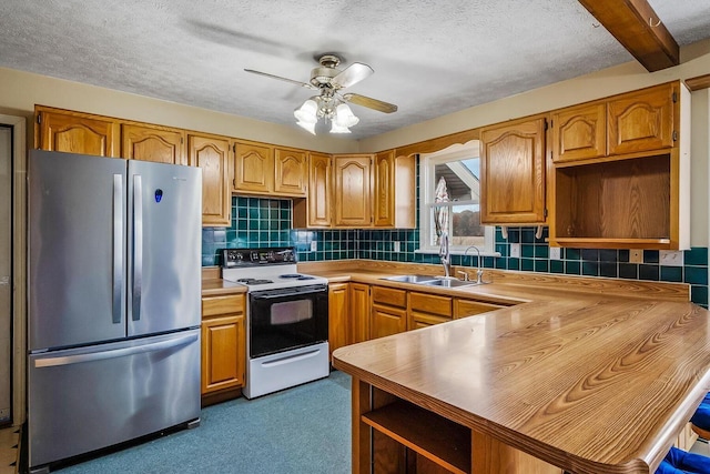 kitchen featuring a sink, open shelves, white electric range oven, and freestanding refrigerator