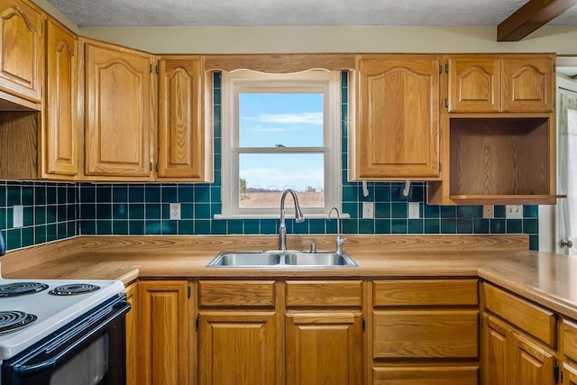 kitchen with tasteful backsplash, a textured ceiling, light countertops, and a sink