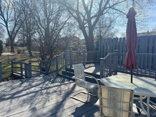 wooden terrace with outdoor dining space and fence