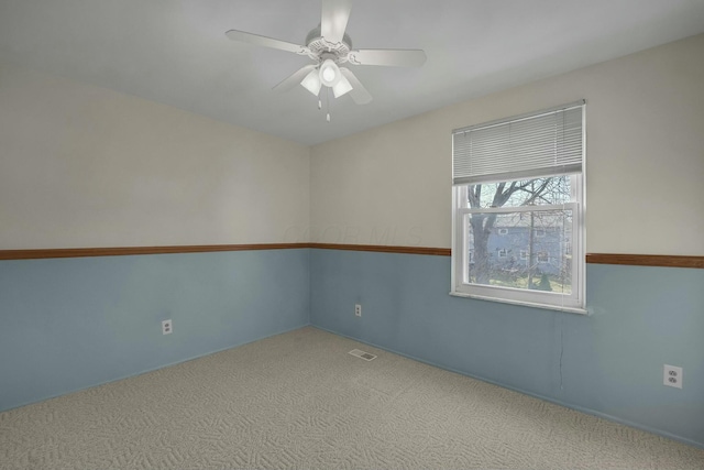 spare room featuring visible vents, carpet, and a ceiling fan