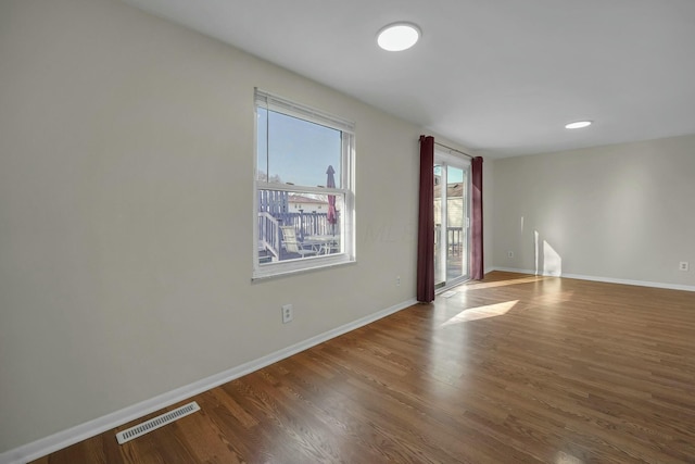 spare room with visible vents, recessed lighting, baseboards, and wood finished floors