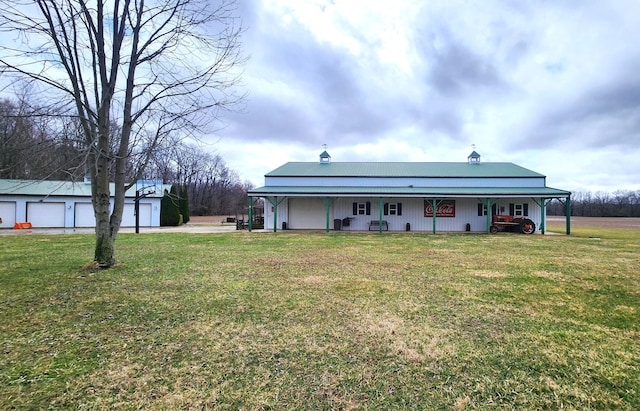 back of house with driveway, a porch, a yard, an outdoor structure, and a garage