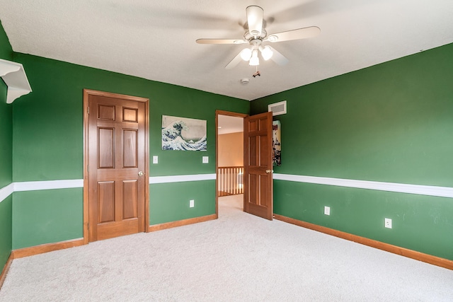 unfurnished bedroom featuring visible vents, a ceiling fan, baseboards, and carpet floors