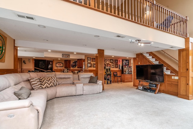 carpeted living room with stairs, a high ceiling, recessed lighting, and visible vents