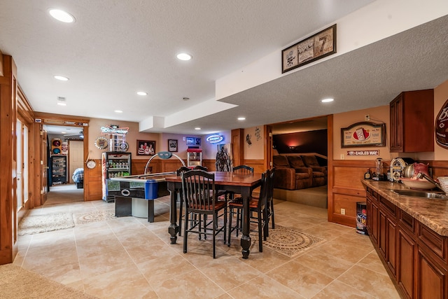 dining area featuring wooden walls, recessed lighting, a wainscoted wall, and a textured ceiling