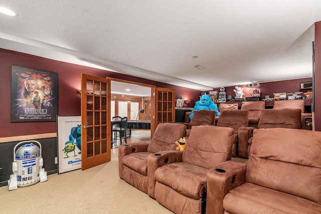 carpeted cinema room featuring french doors and a textured ceiling