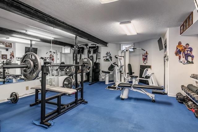 exercise room with baseboards and a textured ceiling