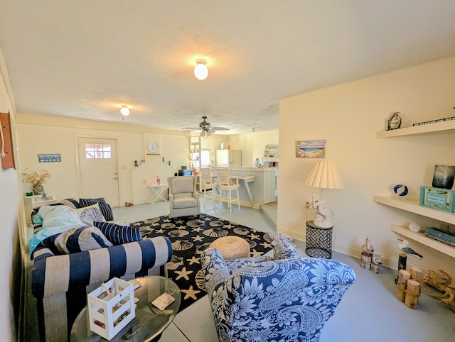 living area featuring baseboards and a ceiling fan