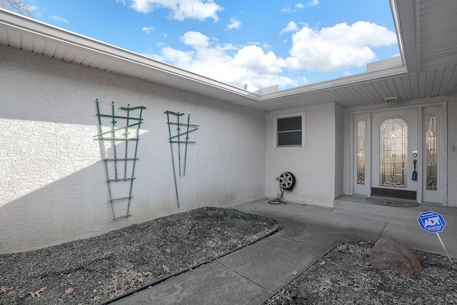 view of exterior entry featuring stucco siding