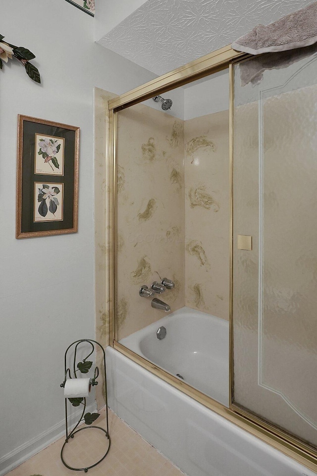 bathroom featuring bath / shower combo with glass door and a textured ceiling