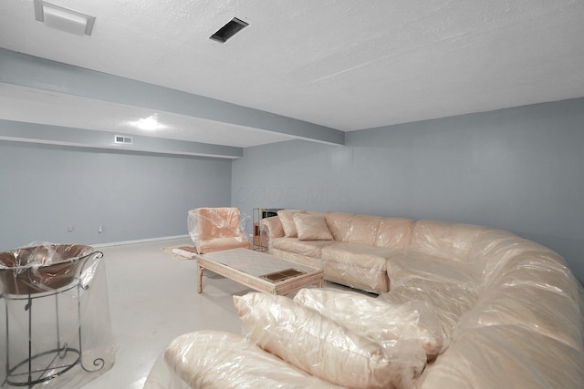 living room with baseboards, visible vents, and a textured ceiling