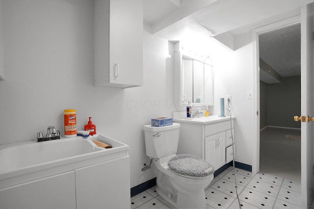 bathroom featuring vanity, toilet, and baseboards