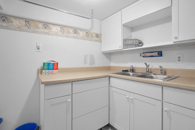 kitchen with white cabinets, open shelves, light countertops, and a sink