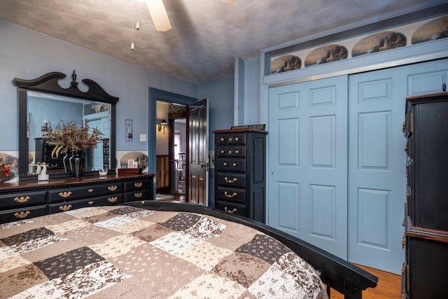 bedroom featuring a ceiling fan, wood finished floors, and a closet