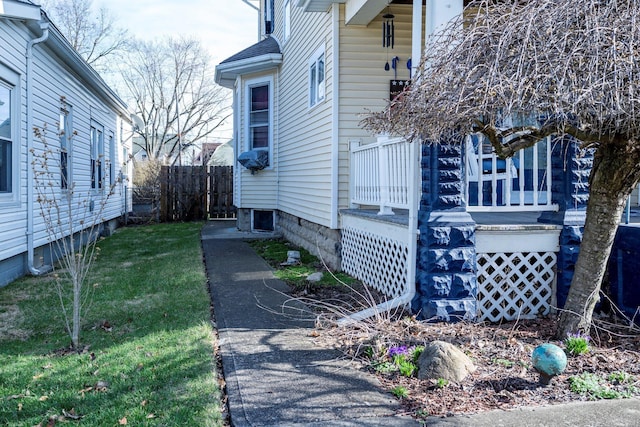 view of home's exterior with a lawn and fence