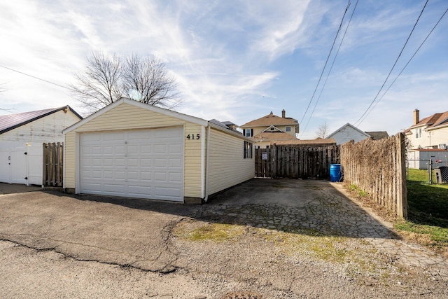 detached garage featuring a gate and fence