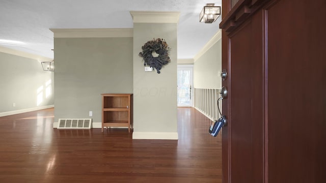 interior space featuring dark wood finished floors, crown molding, baseboards, and visible vents