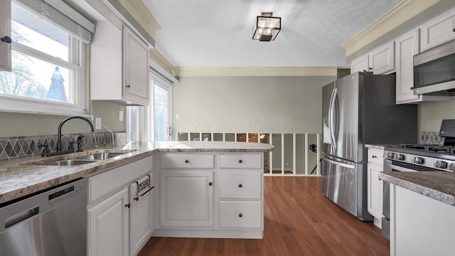 kitchen featuring white cabinetry, a peninsula, stainless steel appliances, and a sink