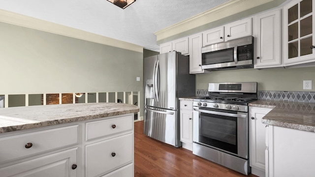 kitchen with glass insert cabinets, appliances with stainless steel finishes, dark wood-style flooring, and white cabinetry