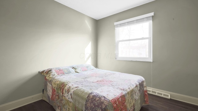 bedroom with dark wood-style floors, baseboards, and visible vents