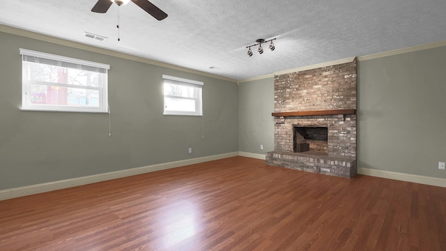 unfurnished living room featuring ceiling fan, visible vents, a textured ceiling, and wood finished floors