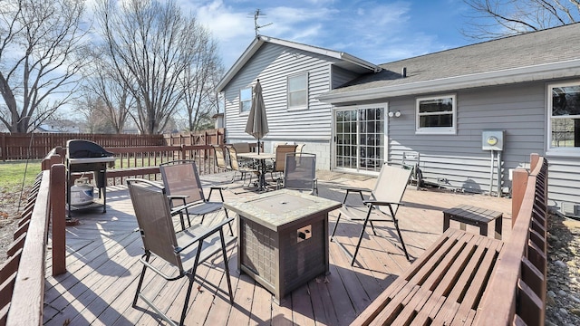 wooden deck with outdoor dining area and fence