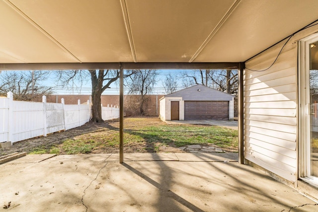 view of patio / terrace featuring a garage, an outdoor structure, and fence