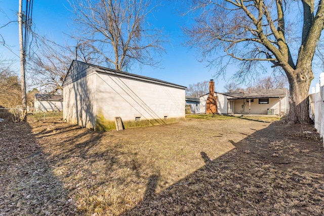 exterior space featuring crawl space, a chimney, and fence