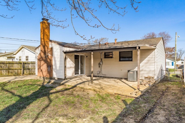 rear view of house featuring a patio, fence, central AC, and a chimney