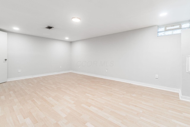 below grade area with recessed lighting, visible vents, light wood-style flooring, and baseboards