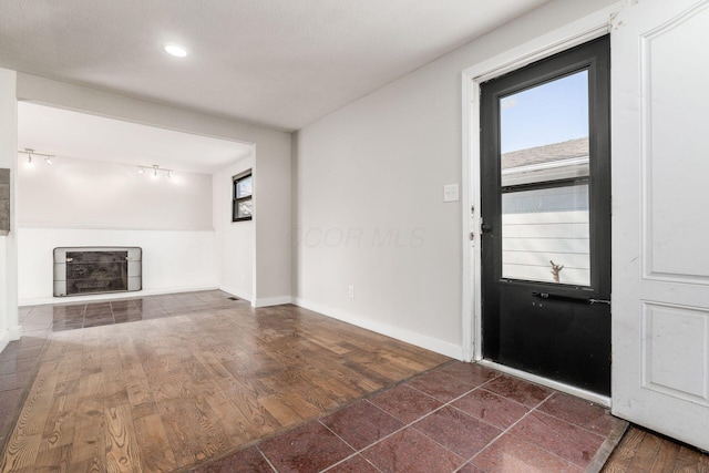 entryway with baseboards and wood finished floors