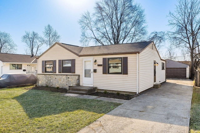 view of front of home featuring a detached garage, stone siding, an outdoor structure, a front yard, and a shingled roof