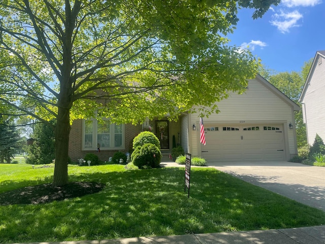 6324 Rossmore Ln, Canal Winchester, OH 43110 - view of property hidden behind natural elements with a garage, brick siding, a front yard, and driveway
