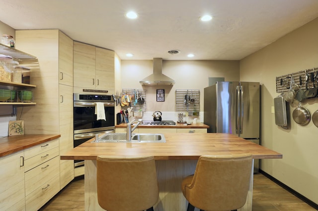 kitchen with visible vents, a sink, wall chimney exhaust hood, wooden counters, and dark wood-style flooring