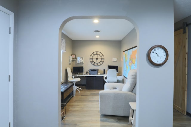 office with arched walkways, visible vents, and light wood-style flooring