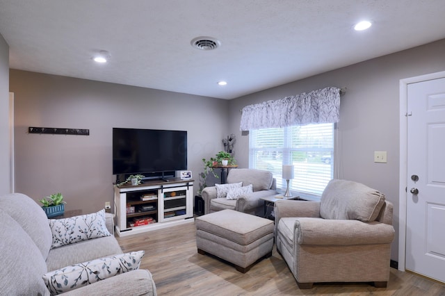 living area with light wood-style flooring, recessed lighting, and visible vents