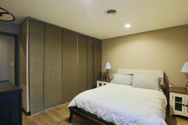 bedroom featuring visible vents and wood finished floors