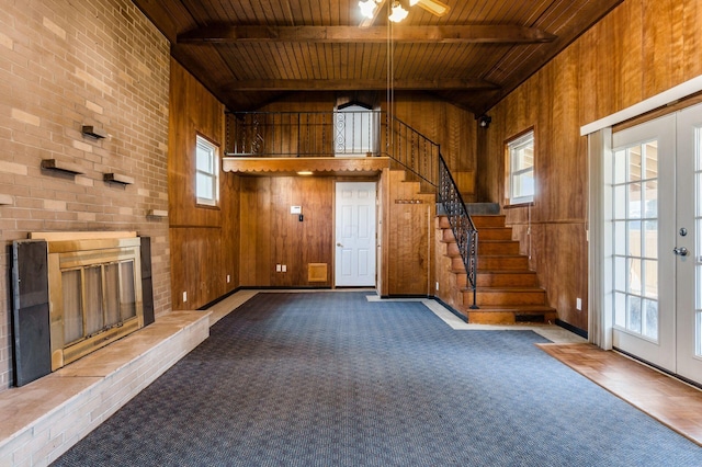 entryway featuring beam ceiling, wooden walls, stairway, and wood ceiling