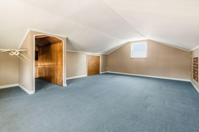 additional living space featuring baseboards, lofted ceiling, and carpet