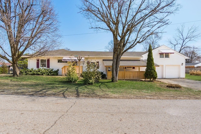 view of front facade featuring a garage, driveway, a front lawn, and fence