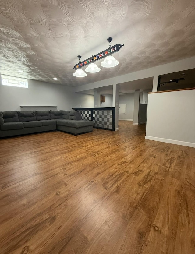 unfurnished living room featuring baseboards and wood finished floors