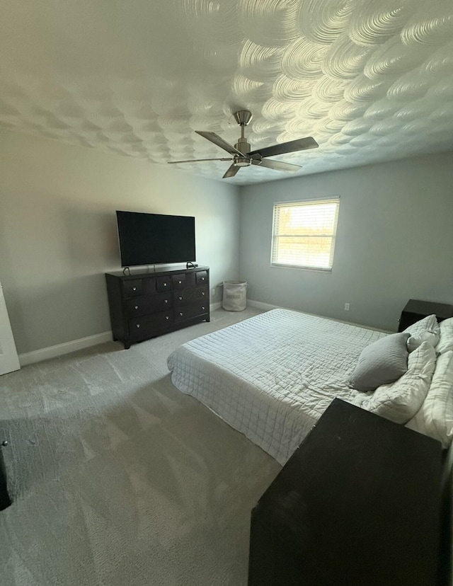 carpeted bedroom with baseboards and ceiling fan