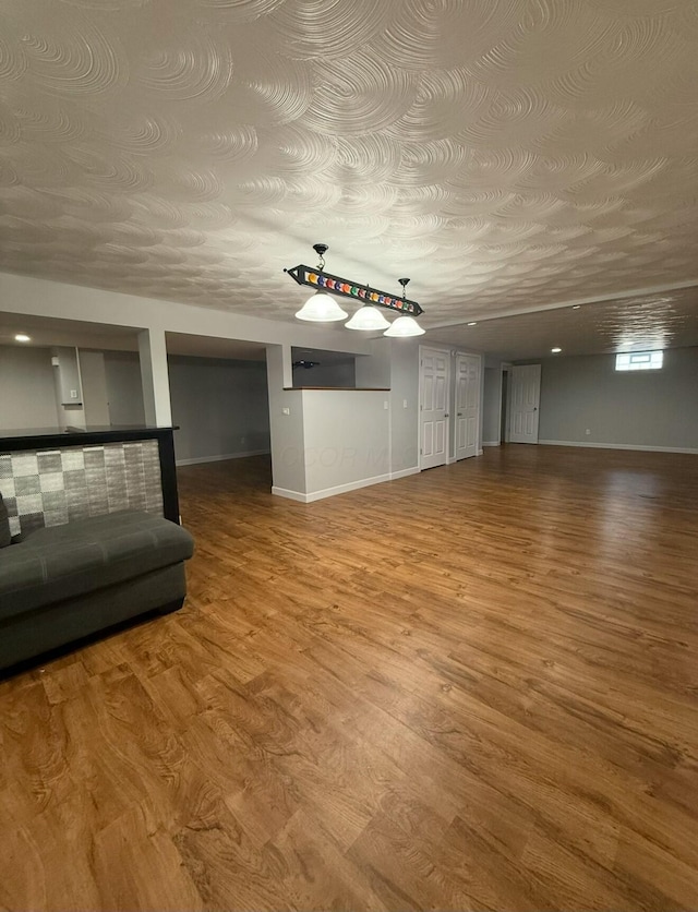 unfurnished living room featuring baseboards and wood finished floors