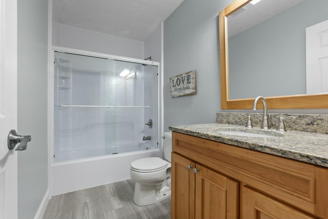 full bath featuring vanity, wood finished floors, tub / shower combination, a textured ceiling, and toilet