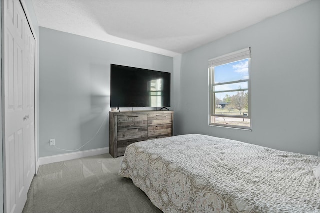 bedroom featuring a closet, carpet flooring, and baseboards